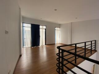 Spacious living room with hardwood flooring and natural light