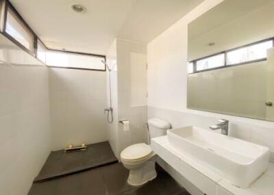 Modern well-lit bathroom with white fixtures and a large mirror