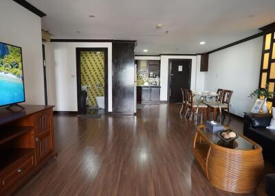 Spacious living room with open floor plan, including a dining area and kitchen in the background