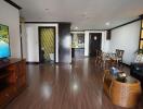 Spacious living room with open floor plan, including a dining area and kitchen in the background