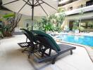 Inviting outdoor pool area with sun loungers and patio umbrella surrounded by lush plants