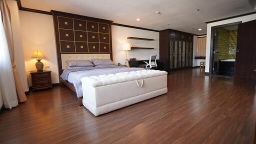 Spacious master bedroom with elegant design and hardwood flooring