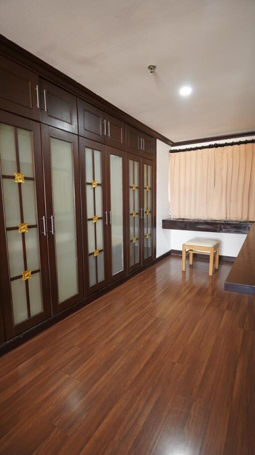 Spacious bedroom with large built-in wardrobe and hardwood floors