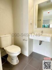 Modern bathroom with white fixtures and tiled wall
