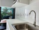 Modern kitchen with stainless steel sink and white countertops
