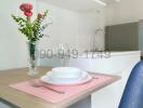 Modern compact kitchen with microwave, dining area, and fresh flowers