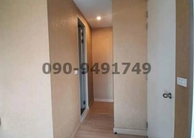 Bright corridor interior leading to rooms with wooden floor and white walls