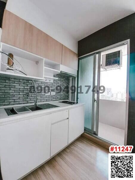 Modern kitchen with white cabinetry and brick backsplash
