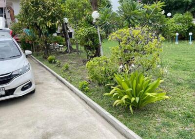 Spacious driveway with a well-maintained garden and car parked