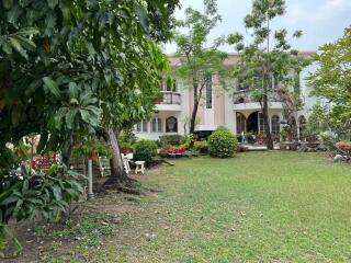 Well-maintained front yard with lush garden and elegant facade of a residential house