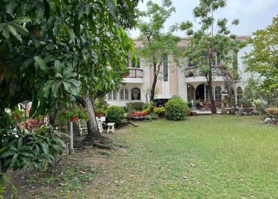 Well-maintained front yard with lush garden and elegant facade of a residential house