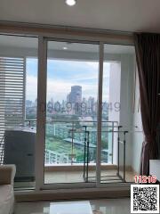 Spacious living room with cityscape view through large balcony doors