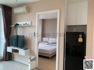 Modern apartment interior showcasing an open living space with a view into the bedroom area