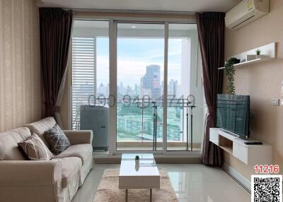 Spacious living room with a large window and city view