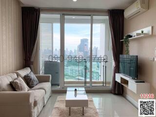 Spacious living room with a large window and city view