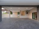 Spacious and well-lit carport area with grey tiled flooring and modern lighting