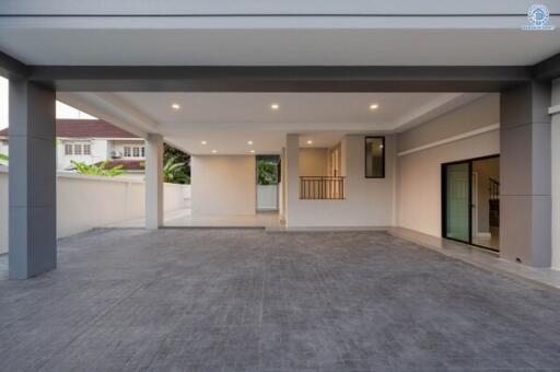 Spacious and well-lit carport area with grey tiled flooring and modern lighting