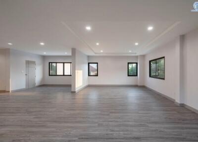 Spacious empty living room with modern gray flooring and recessed lighting