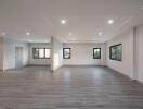 Spacious empty living room with modern gray flooring and recessed lighting