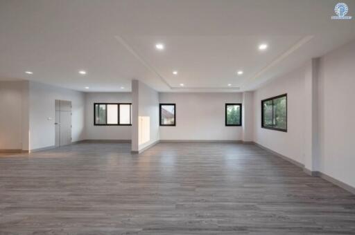 Spacious empty living room with modern gray flooring and recessed lighting