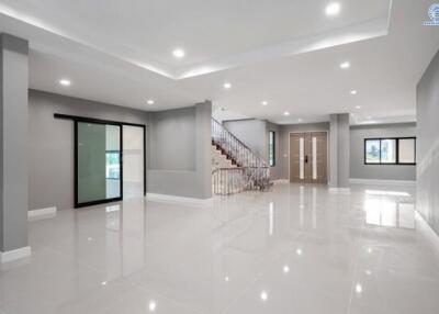 Spacious and bright modern living room with staircase and glossy tiled floor