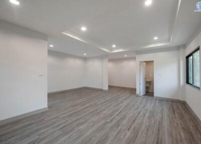 Spacious and well-lit empty room with wooden flooring