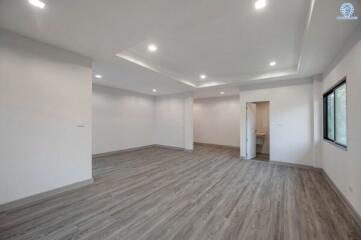 Spacious and well-lit empty room with wooden flooring