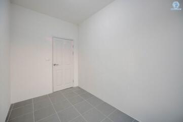 Empty room with white walls and gray tiled floor