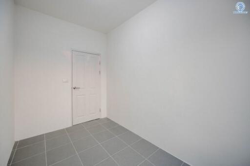 Empty room with white walls and gray tiled floor