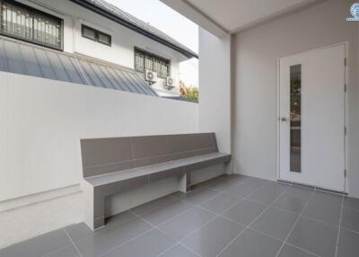Spacious tiled patio with bench and modern exterior