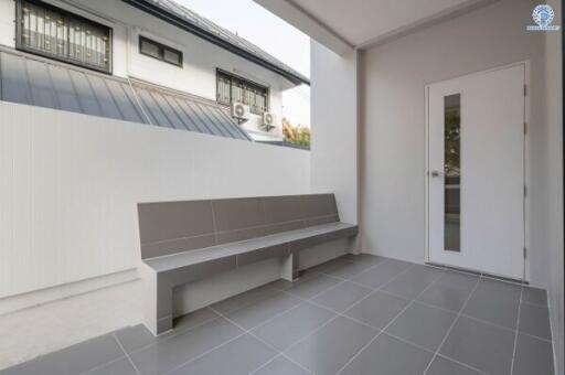 Spacious tiled patio with bench and modern exterior