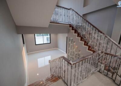 Elegant staircase in a modern home interior with iron railings and natural lighting