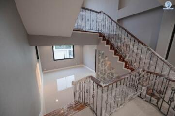 Elegant staircase in a modern home interior with iron railings and natural lighting