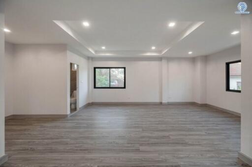 Spacious and modern living room with recessed lighting and large window