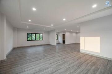 Spacious and well-lit empty living room with hardwood floors