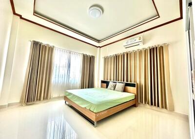 Spacious and well-lit bedroom with a large bed and elegant curtains