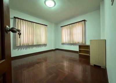 Spacious unfurnished bedroom with hardwood floors and natural light