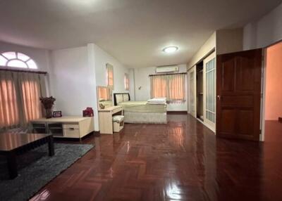 Spacious bedroom with hardwood floors and ample natural light