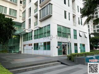 Modern white building exterior with large glass windows and sliding entrance doors