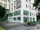 Modern white building exterior with large glass windows and sliding entrance doors