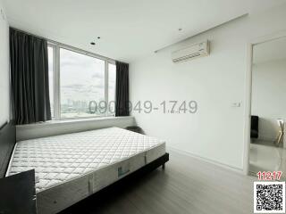 Spacious bedroom with large window and city view