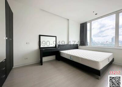 Spacious bedroom with large windows and city view