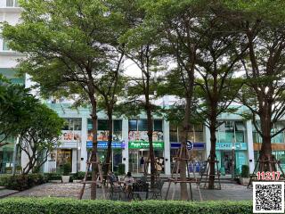 Lush outdoor common area of a residential building with benches and greenery