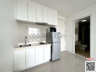 Modern white kitchen with stainless steel appliances and adjacent bathroom