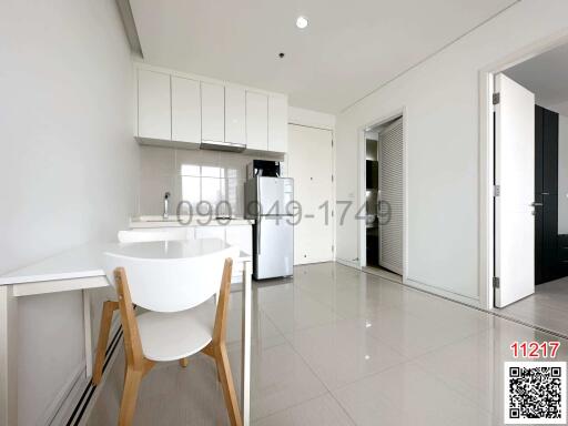 Modern kitchen with white cabinetry and breakfast bar in a bright apartment