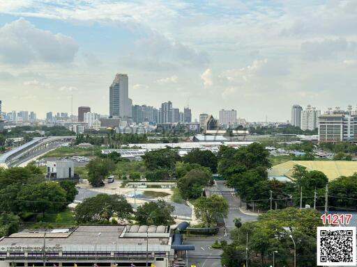 Cityscape view from a high-rise showing buildings, roads, and greenery