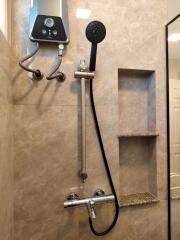 Modern bathroom shower with wall mounted fixtures and built-in shelving