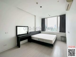 Spacious bedroom with large windows and city view