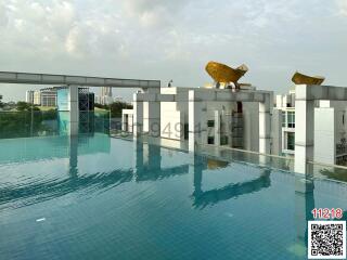 Luxurious rooftop swimming pool with cityscape view and artistic sculptures