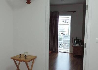 Bright and welcoming hallway leading to a living area with balcony access